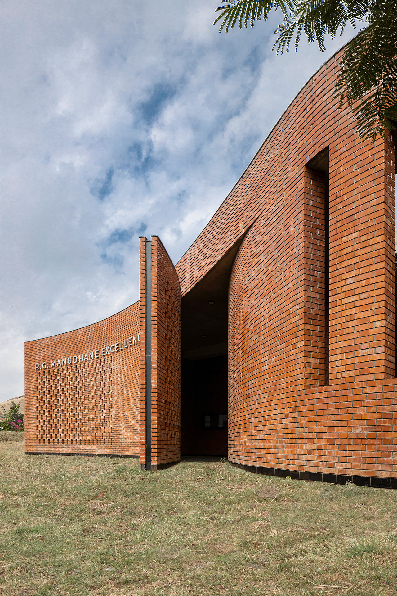 Curved brick building by Morphogenesis with perforated brickwork, labeled 