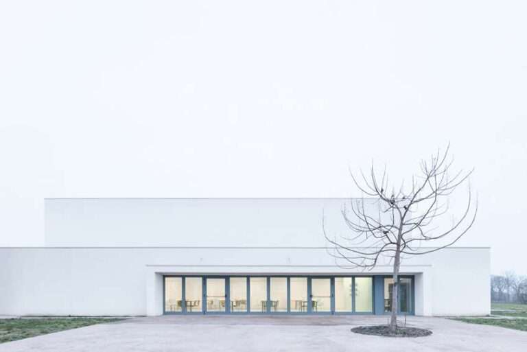 vertical white pillars compose rhythmic facade enfolding primary school in italy