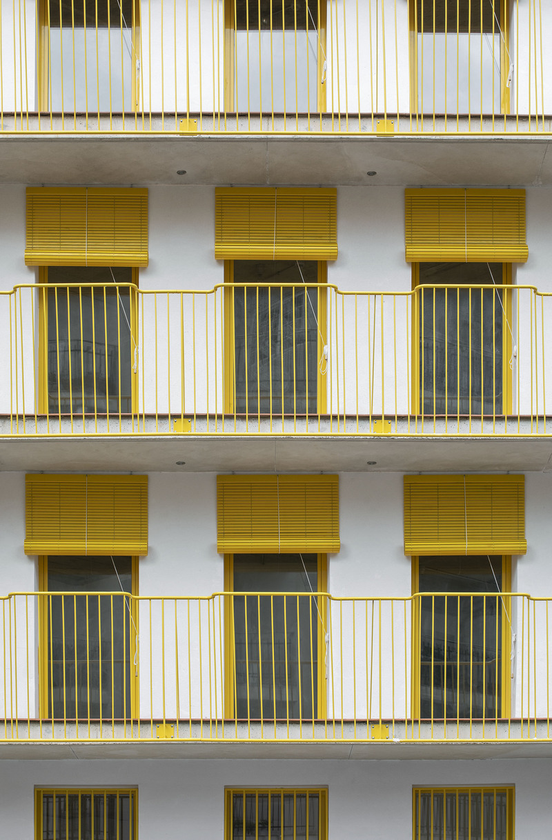 yellow steel, concrete, and circular openings revive corner building in spain as apart-hotel - 4