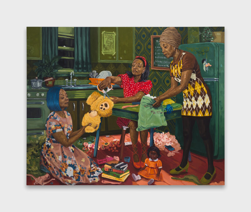 Three women in colorful dresses interact with a teddy bear, clothing, and books in a vintage kitchen—evoking Wangari Mathenge’s Re-membering amid patterned walls and a green refrigerator.